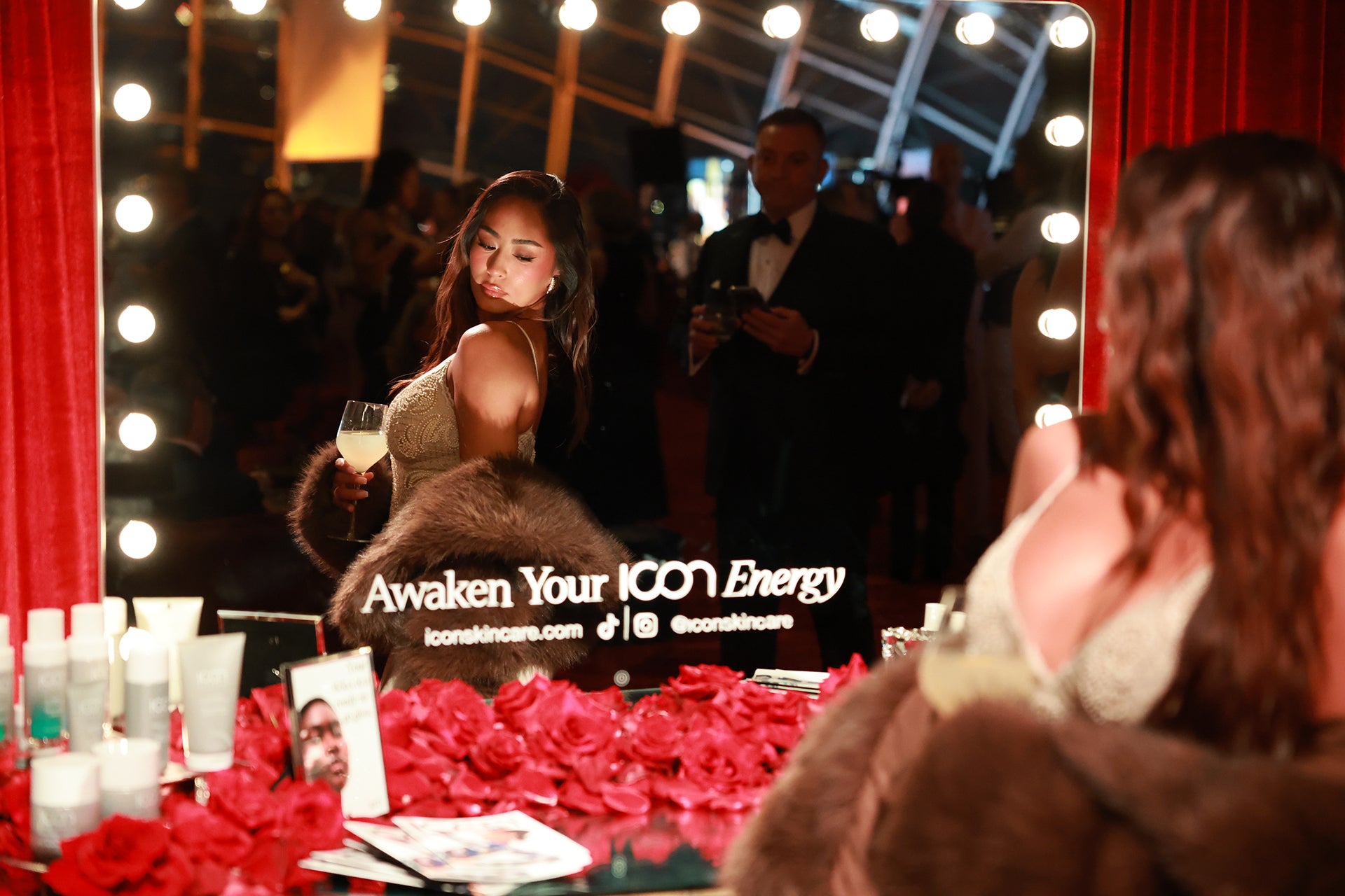 Woman in a glamorous setting with a mirror and decorative items.